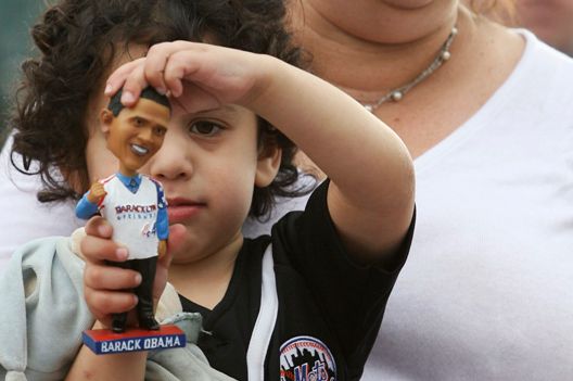 Barak Landis, 3, plays with his Obama bobble head as his mother Judy holds him during the "Baracklyn" Cyclones game last night.